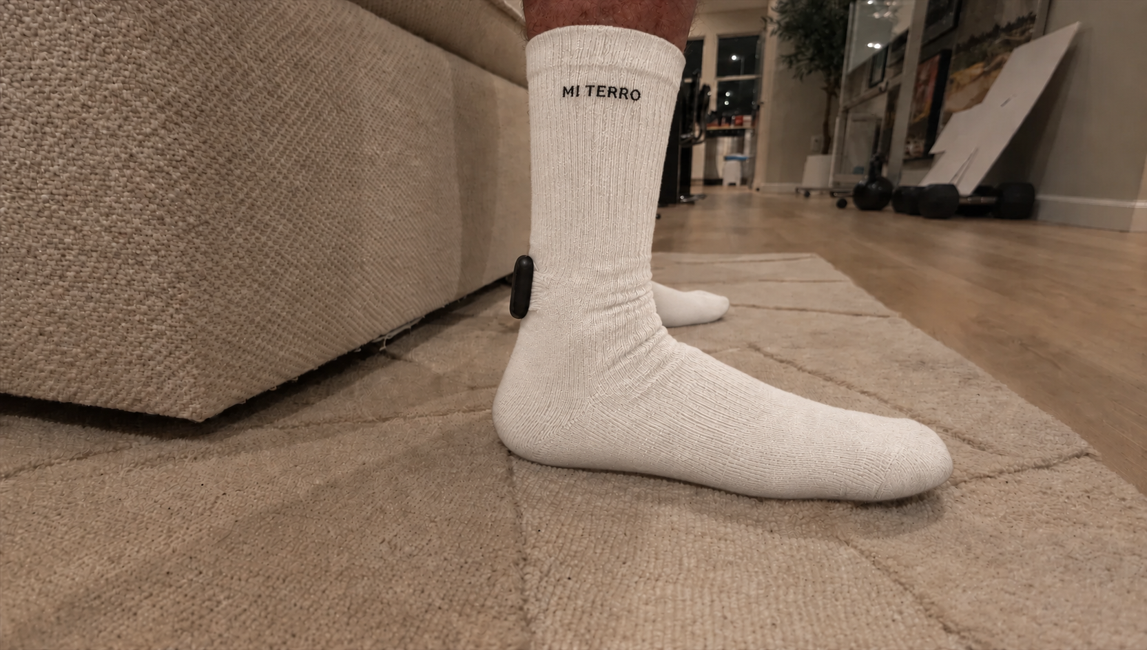 Worn Mi Terro Care Sock prototype in a white colorway visualization, with cuff logo and enclosed rear module